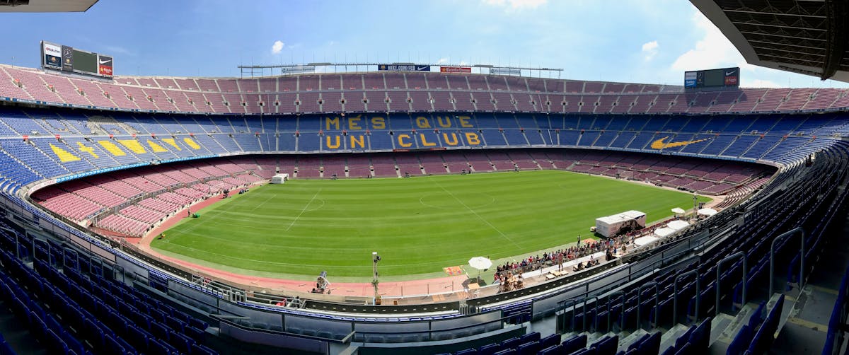 Panoramic view of Camp Nou stadium showcasing its iconic seating and field.