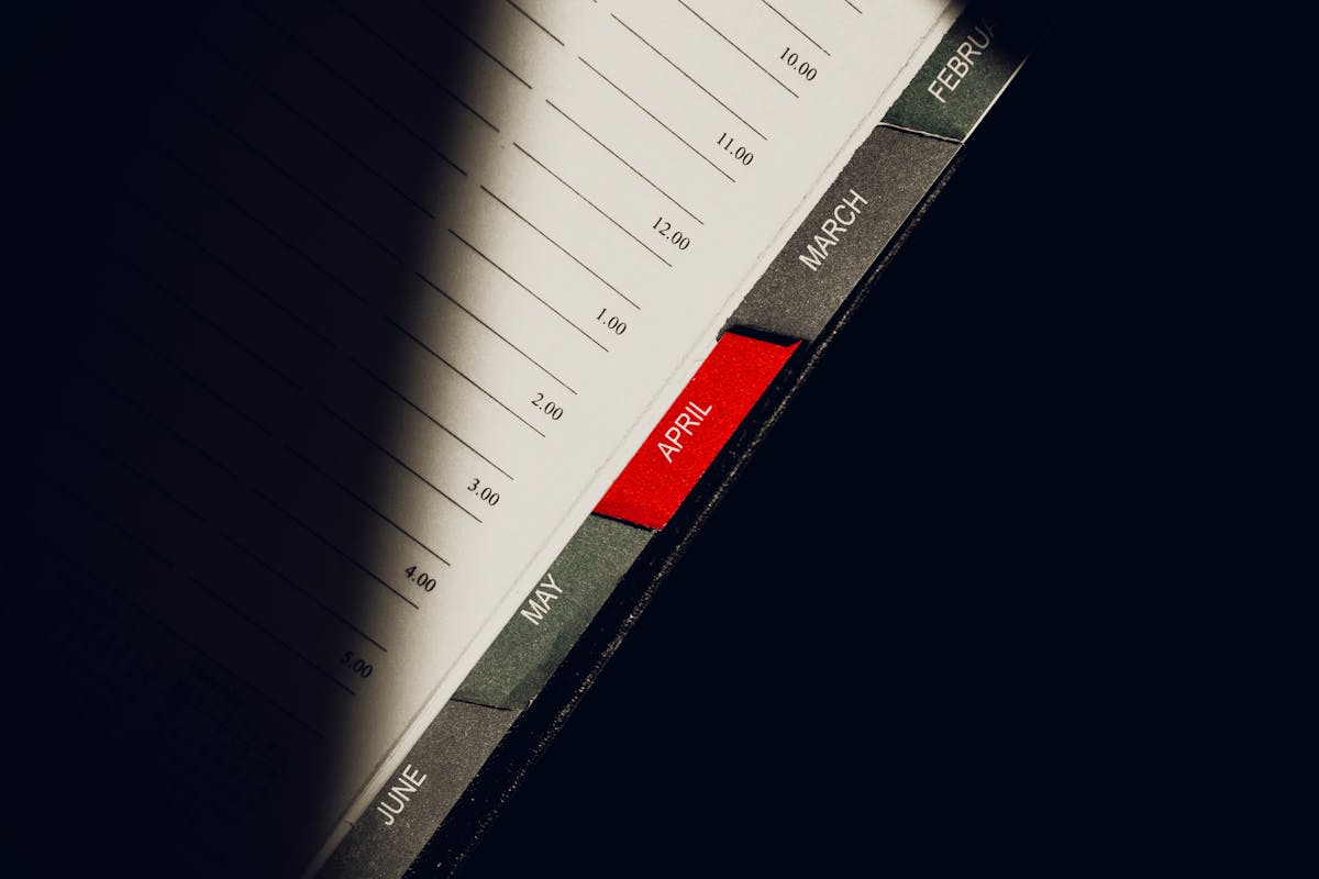 A close-up shot of a planner highlighting the month of April with visible monthly tabs.